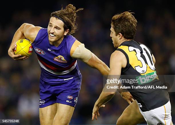 Marcus Bontempelli of the Bulldogs in action ahead of Reece Conca of the Tigers during the 2016 AFL Round 16 match between the Western Bulldogs and...