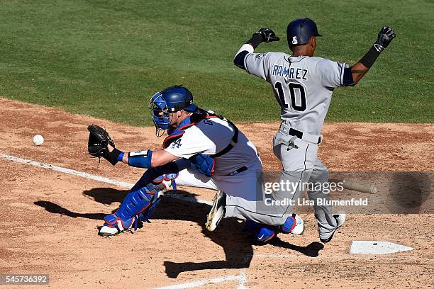 Alexei Ramirez of the San Diego Padres scores in the fifth inning against Yasmani Grandal of the Los Angeles Dodgers at Dodger Stadium on July 9,...