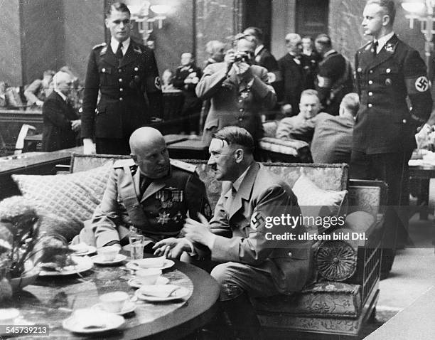 Empfang im 'Führerbau' am Königlichen Platz ; Adolf Hitler undBenito Mussolini im Gespräch; in derMitte: der Fotograf Heinrich Hoffmann;ganz rechts:...