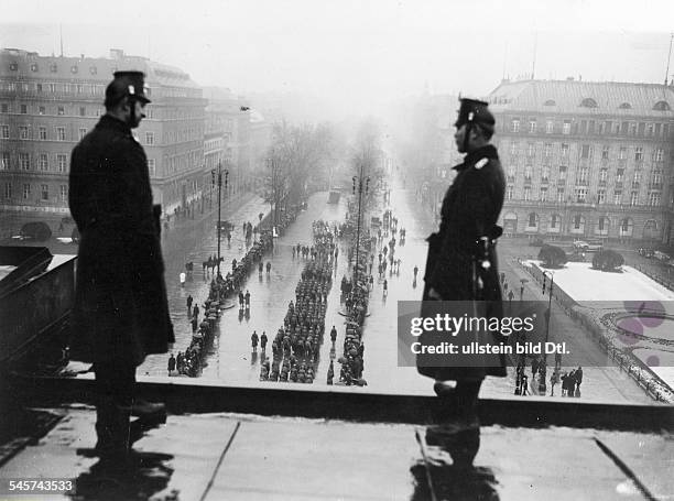 Polizeibeamte beobachten vom BrandenburgerTor aus einen Aufmarsch der SA nach derReichstagswahl.- Anfang März 1933