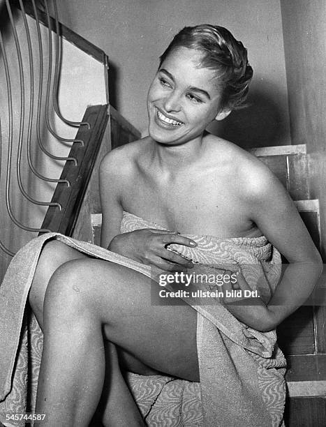 Swiss actress Ursula Andress, 1956. Schauspielerin, Schweiz- Halbportrait, mit einem Badetuch verhuellt, laechelt- 1956