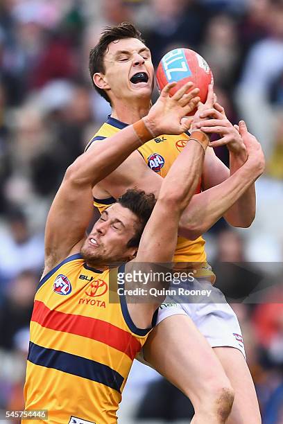 Kyle Hartigan and Jake Lever of the Crows compete for a mark during the round 16 AFL match between the Carlton Blues and the Adelaide Crows at...