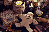 Close up of woodoo doll, knife, candles and magic objects