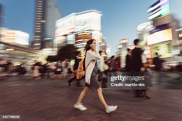 frau am telefon bei shibuya kreuzung - shibuya stock-fotos und bilder