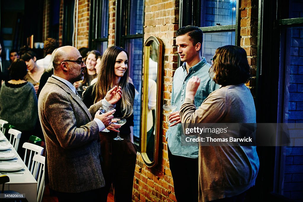 Friends talking and having drinks at dinner party