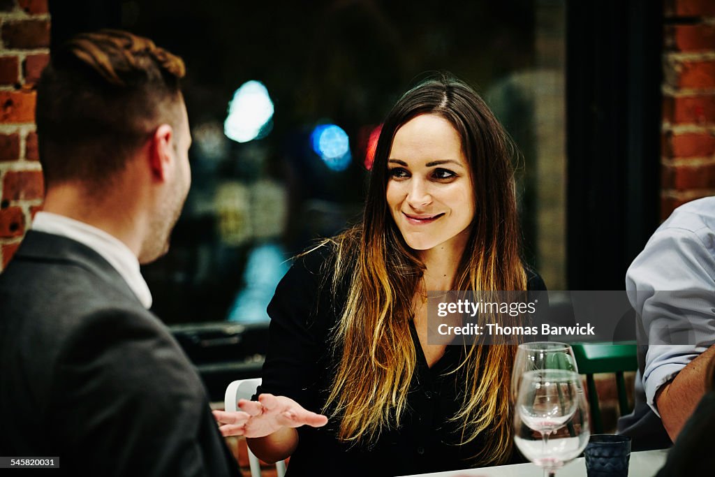 Woman in conversation with friend during dinner