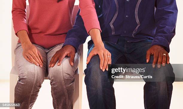 husband and wife with hands on knees - hand on knee stock pictures, royalty-free photos & images