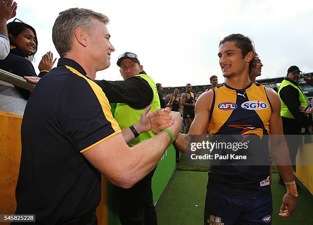 Adam Simpson, coach of the Eagles acknowledges Sharrod Wellingham after playing his 150th game during the round 16 AFL match between the West Coast...
