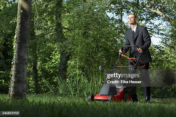 man in suit mowing the lawn - mowing stock pictures, royalty-free photos & images