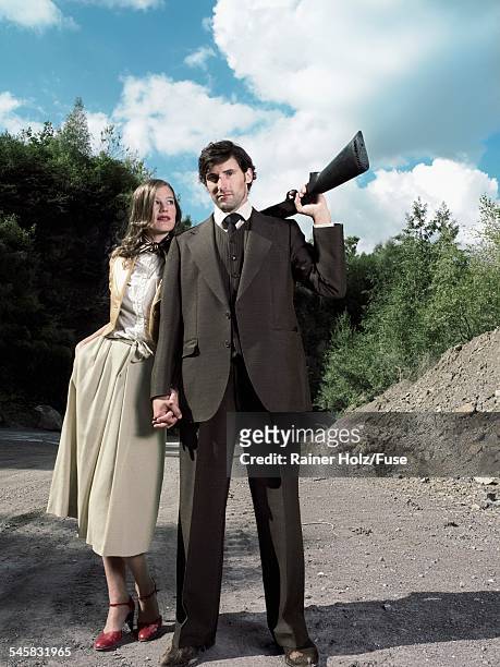 woman and man holding shotgun - fond holz stock pictures, royalty-free photos & images