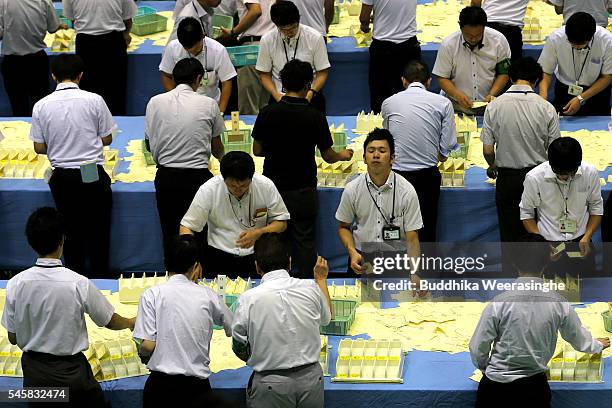 Election staff member count votes, which were cast in the Parliament's upper house election, at a ballot counting center on July 10, 2016 in Himeji,...