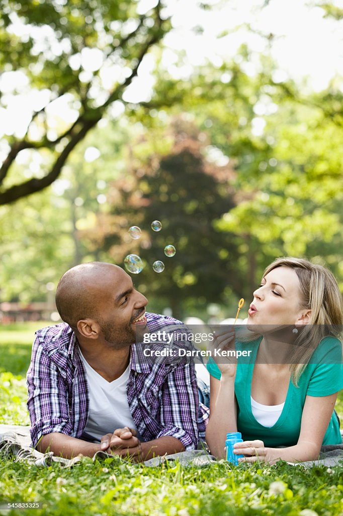 Young couple blowing bubbles
