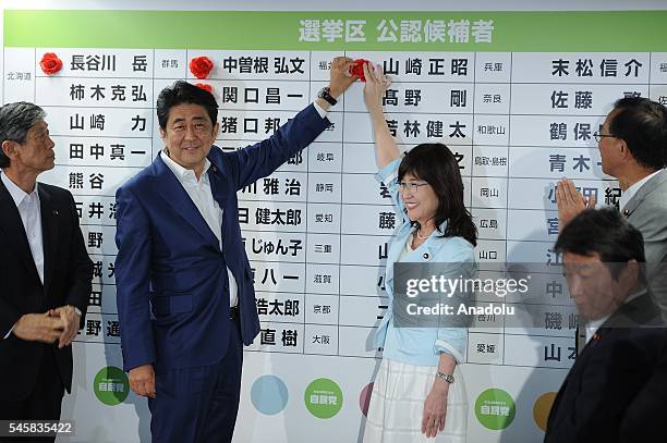 Japanese Prime Minister Shinzo Abe of the Liberal Democratic Party places roses above names of elected candidate of the party at the head quarter of...