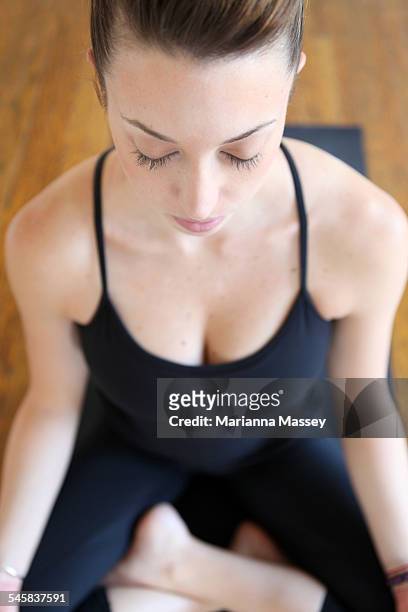 young women meditating - halber lotussitz stock-fotos und bilder