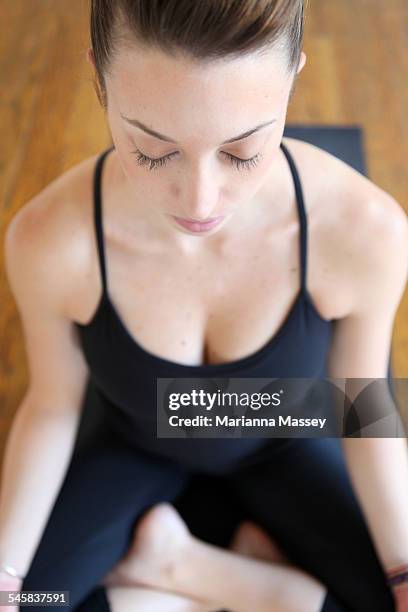 young women meditating - half lotus position stock pictures, royalty-free photos & images