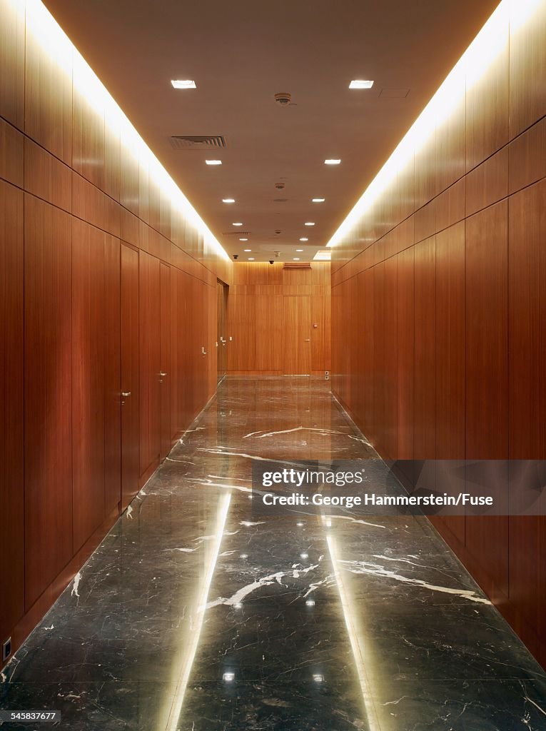 Wood paneled hallway with marble floor