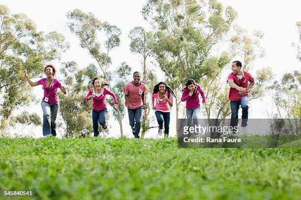 two teachers with group of teenage students (16-17) racing in field - portrait of school children and female teacher in field stock pictures, royalty-free photos & images