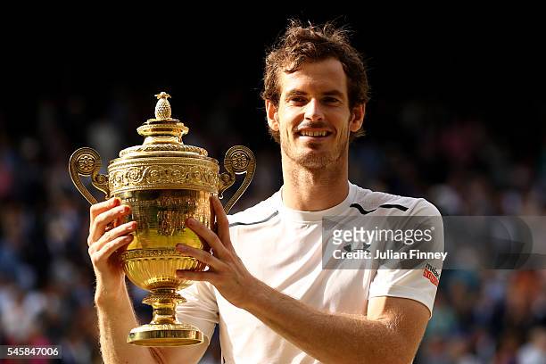 Andy Murray of Great Britain lifts the trophy following victory in the Men's Singles Final against Milos Raonic of Canada on day thirteen of the...