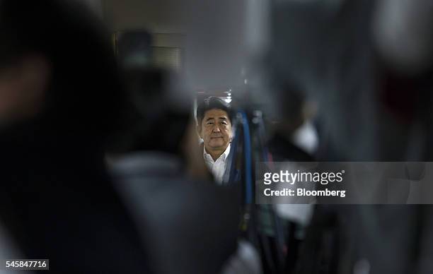 Shinzo Abe, Japan's prime minister and president of the Liberal Democratic Party , is seen through television cameras as he arrives at a conference...