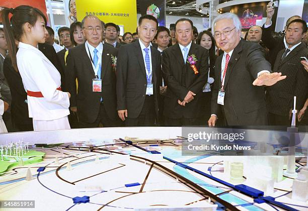 China - Toshiba Corp. President Norio Sasaki explains to Chinese officials about an exhibition at the Japan-China Green Expo 2011 in Beijing on June...