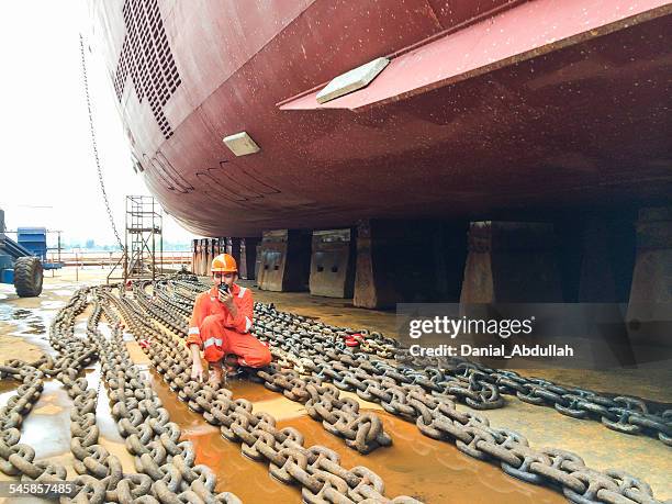 dock worker in a shipyard talking on a walkie talkie - ship builders stock pictures, royalty-free photos & images