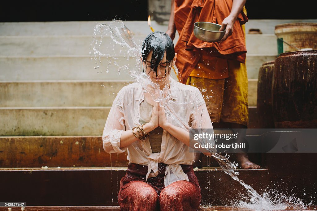Cambodia, Buddhist monk water blessing young woman