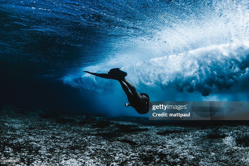 Woman wearing mermaid flippers swimming underwater, Hawaii, America, USA