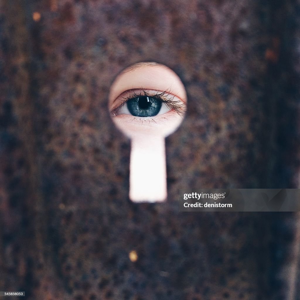 Girl (8-9)  looking through keyhole