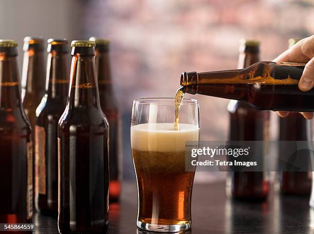 usa, new jersey, hand pouring beer - beer bottle stock pictures, royalty-free photos & images