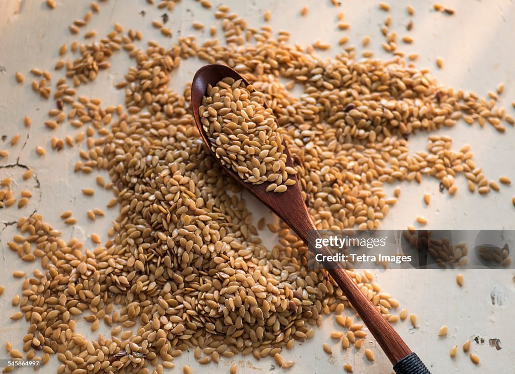 Flax seeds and wooden spoon on white