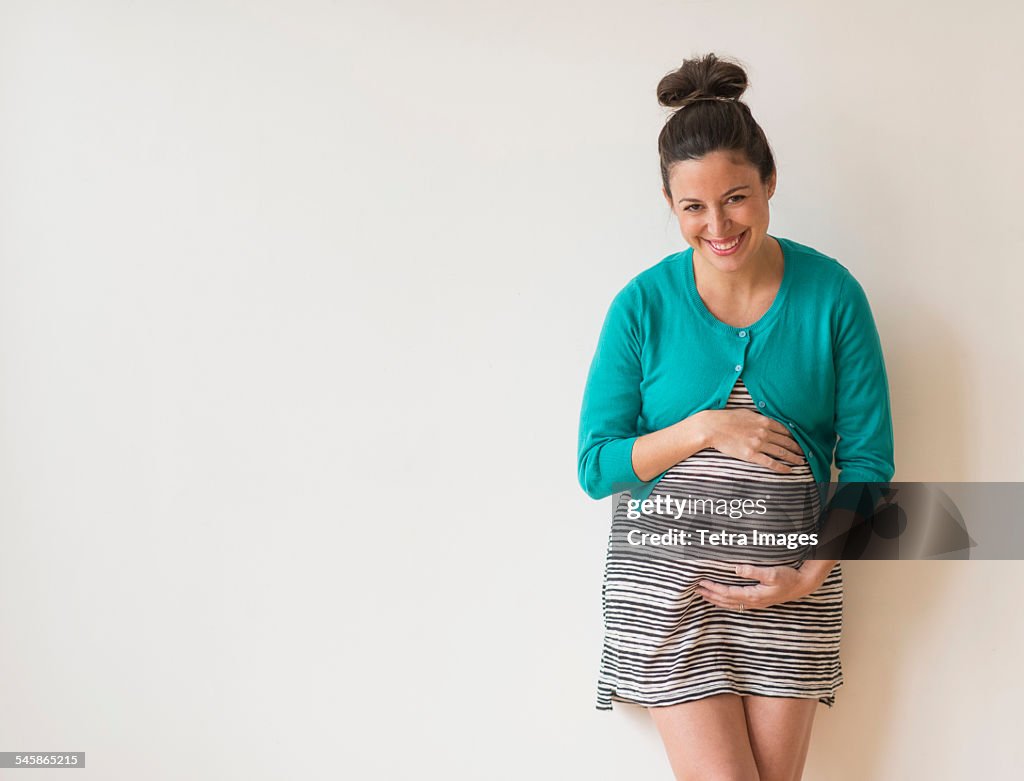 Studio shot of happy pregnant woman