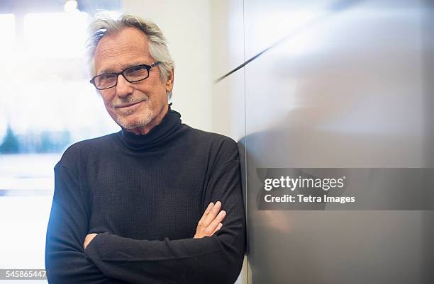 usa, new jersey, portrait of smiling senior man standing in office corridor - turtleneck 個照片及圖片檔