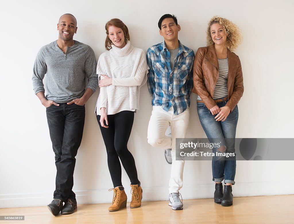 USA, New Jersey, Group of friends standing in front of white wall