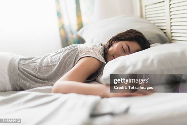 usa, new jersey, young woman sleeping in bed - auf dem bauch liegen stock-fotos und bilder