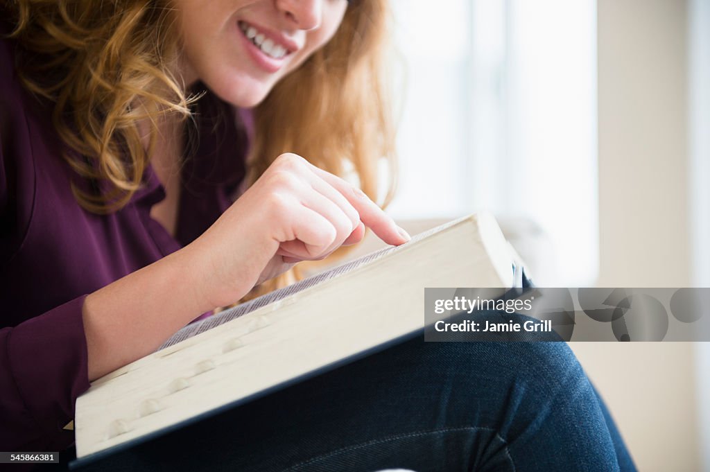USA, New Jersey, Young woman reading book