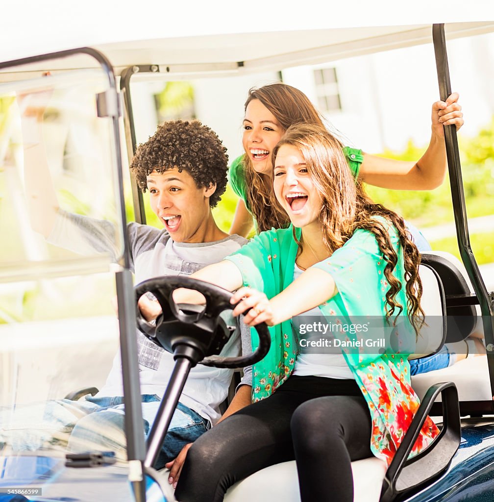 USA, Jupiter, Florida, Group of friends (14-15) driving golf cart