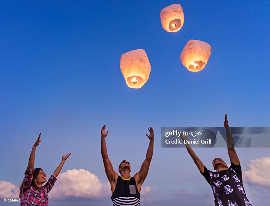 USA, Florida, Jupiter, Young people with illuminated lanterns at sunset