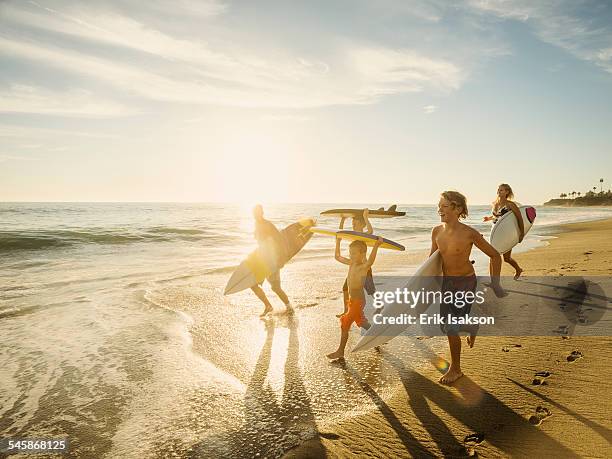 usa, california, laguna beach, family with three children (6-7, 10-11, 14-15) with surfboards on beach - surf beach stock-fotos und bilder