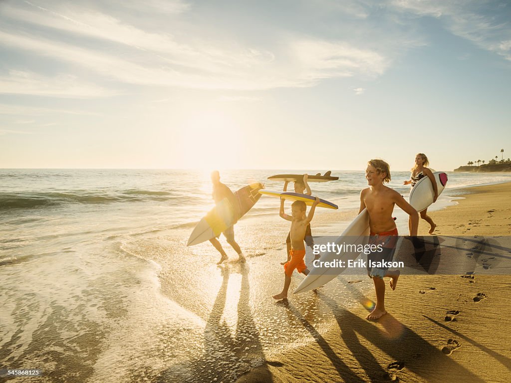 USA, California, Laguna Beach, Family with three children (6-7, 10-11, 14-15) with surfboards on beach