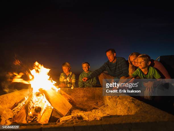 usa, california, laguna beach, family with three children (6-7, 10-11, 14-15) cooking marshmallows - family time stock pictures, royalty-free photos & images