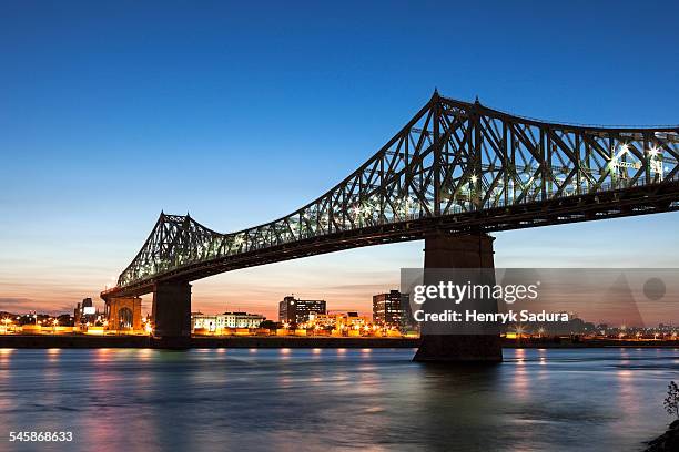 canada, quebec, montreal, st. helens island, illuminated jacques cartier bridge against sky - river st lawrence stock-fotos und bilder