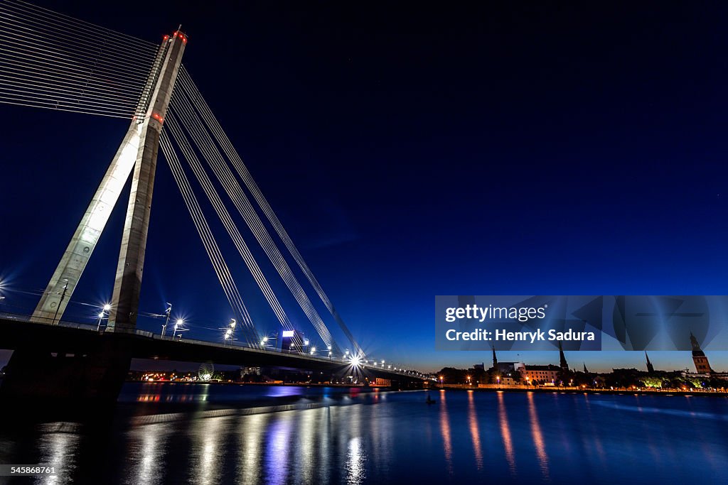 Latvia, Riga, River Daugava, Illuminated Vansu Bridge reflecting in river