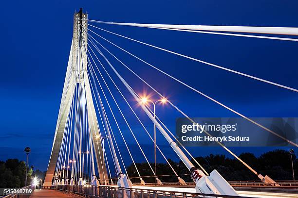 poland, mazowieckie, warsaw, tower and cables of illuminated swietokrzyski bridge against night sky - bridge architecture up close night stock pictures, royalty-free photos & images
