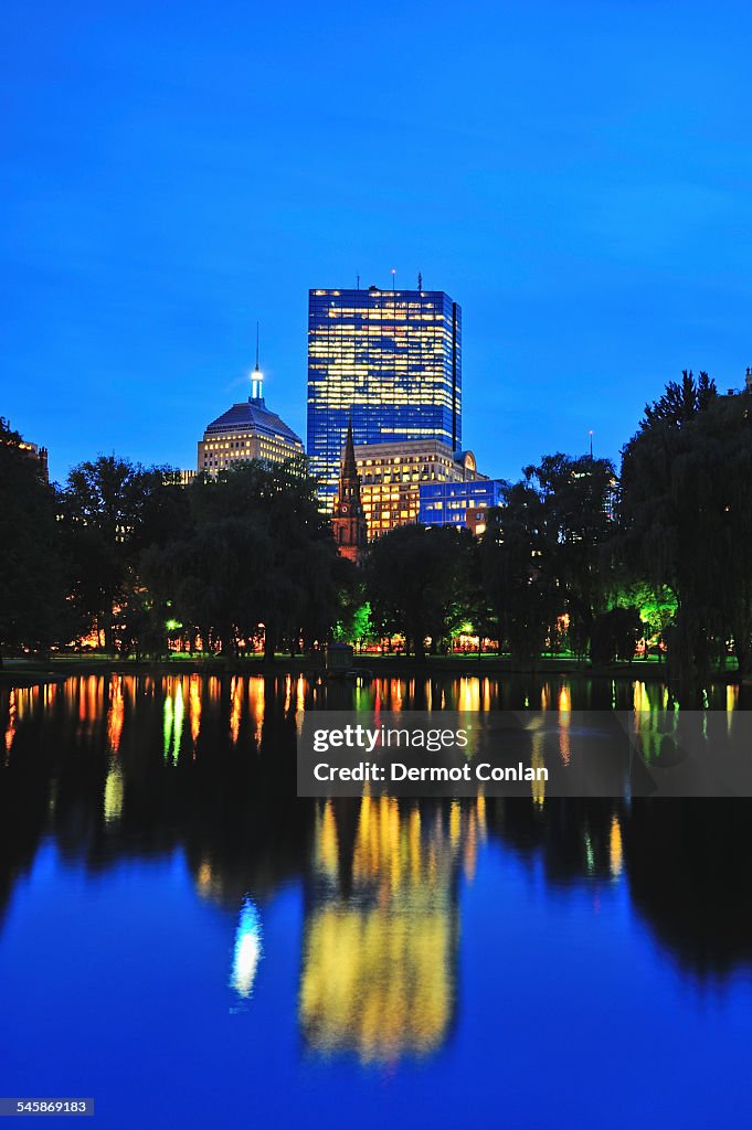 USA, Massachusetts, Boston, Office building reflecting in pond in Public Gardens at dusk