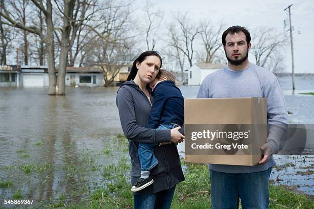 usa, illinois, parents with son standing in flooded town - home disaster fotografías e imágenes de stock