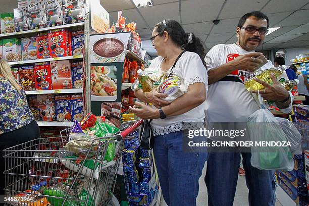 Venezuelans shop for groceries at a supermarket in Cucuta, Norte de Santander department, Colombia on July 10, 2016. Thousands of Venezuelans crossed...