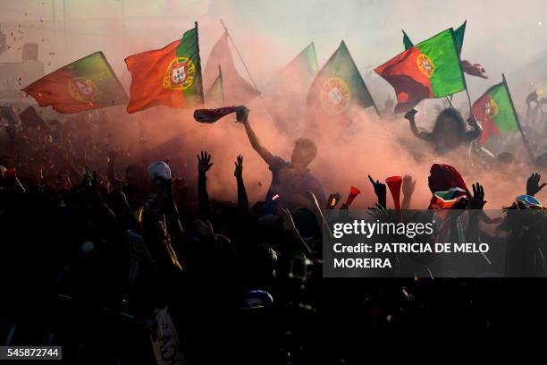 Portugal's national football team supporters wave flags at Terreiro do Paco square in Lisbon on July 10, 2016 as they watch on a giant screen the...