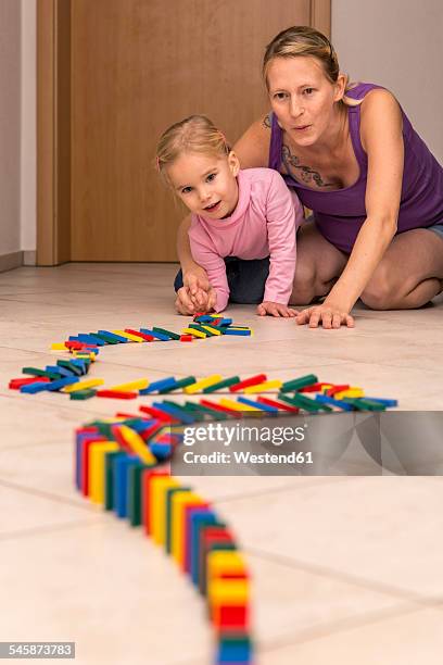 mother and daughter with row of dominos - domino stock-fotos und bilder