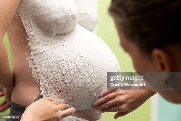 woman shaping plaster cast of pregnant woman - shaping future stock-fotos und bilder