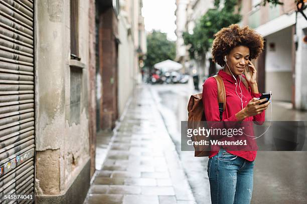 smiling young woman hearing music with earphones - red headphones stock pictures, royalty-free photos & images